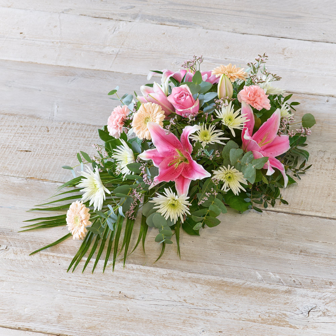 Heart-shaped floral tribute with red roses and white carnations
