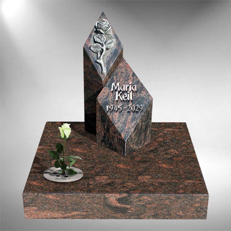 Hand-carved granite headstone with intricate floral border design